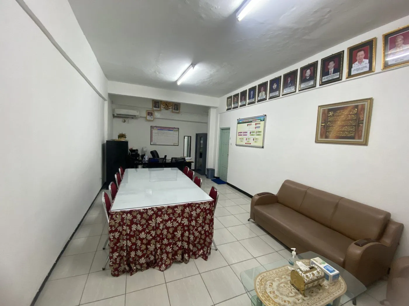 Ruang kepala sekolah dengan meja rapat dan sofa.